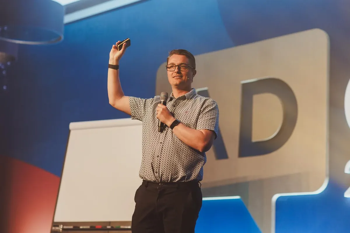 Paul Green speaking on stage at AdCon