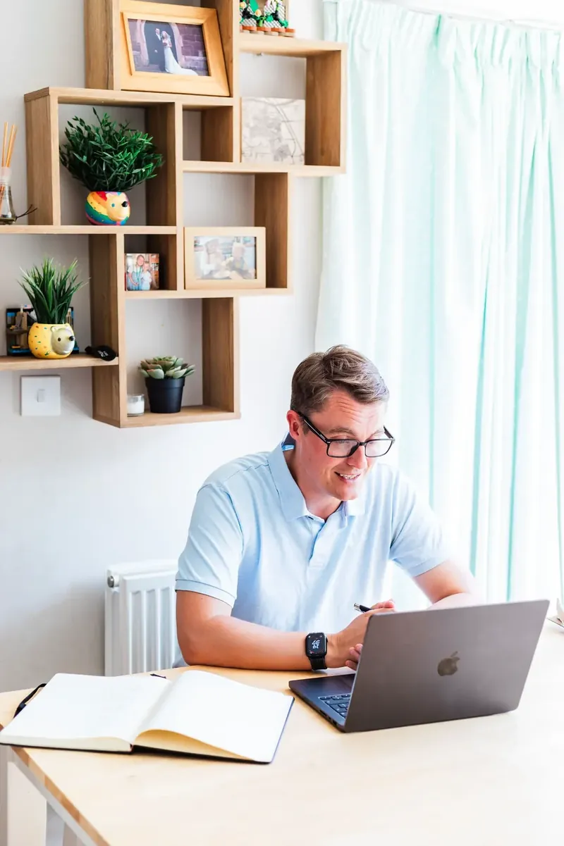 Paul Green working at a laptop with a notebook beside him